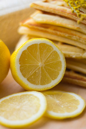Viennese wafers pile and sliced lemon. Sliced lemon on a wooden board. Fruits are chopped. Sour lemon. Citrusの写真素材