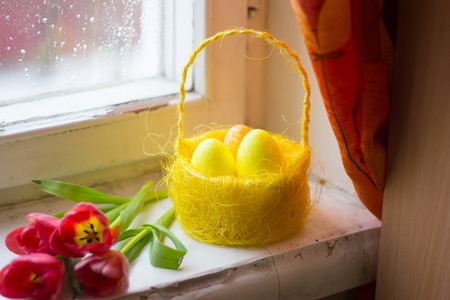 Easter card. Painted eggs in a basket and flowers in a vase. Orthodox holiday. Religion and cultureの写真素材