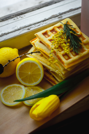 Viennese wafers pile and sliced lemon. Sliced lemon on a wooden board. Fruits are chopped. Sour lemon. Citrusの写真素材