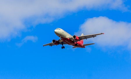 The plane flies in the sky in clear weather. Airplane in the sky. Airplane before landing. The plane is flying. Russia, St. Petersburg, April 27, 2018のeditorial素材