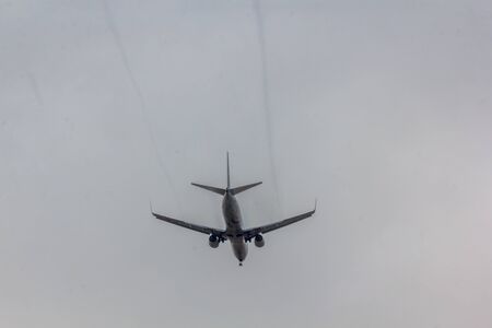 The plane flies in the sky in rainy weather. Airplane in the sky. Airplane before landing. The plane...