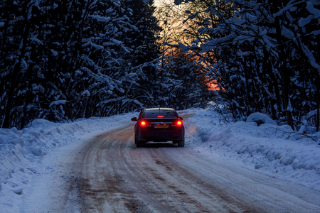 Car on the winter road in the evening. Night road. Road outside the city. Black car Car out of town in the winter. Russia, Leningrad region, March 1, 2018のeditorial素材