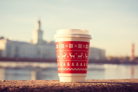 a cup of coffee on the background of the river. hot drink in the city. glass of coffeeの写真素材