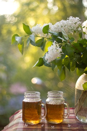 Cold drink tea black in glasses. Tea on the balcony. Tea for Two. Cold drink. Bouquet of flowers . Flowers and teaの写真素材