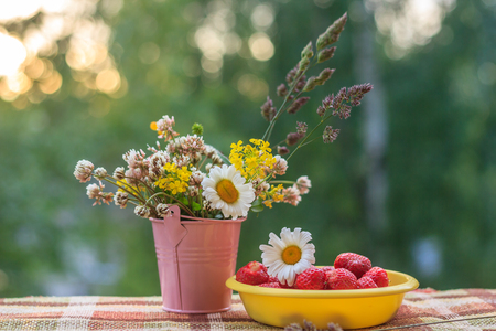 Berries strawberries and a bouquet of wildflowers. Summer garden berries. Red sweet berries.の写真素材