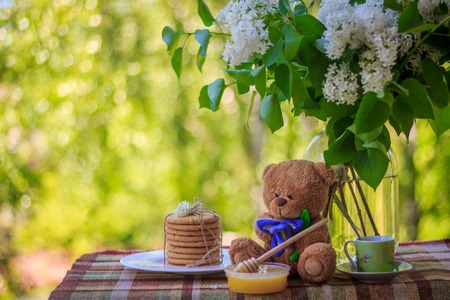 A cup of tea, cookies and flowers of lilac. Tea on the balcony. Tea drinking in nature. Bouquet of flowers .の写真素材