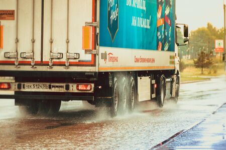 The car goes through a puddle. Puddles on the road. Water from the wheels. Road after the rain....