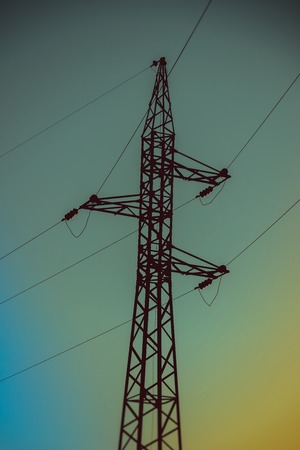 Electricity poles in the field. Industry electricity. Light in the house. Metal structures in the field. Sunset in the fieldの写真素材