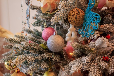 Christmas tree in the living room. Pink and blue ornaments on the Christmas tree. New Year...
