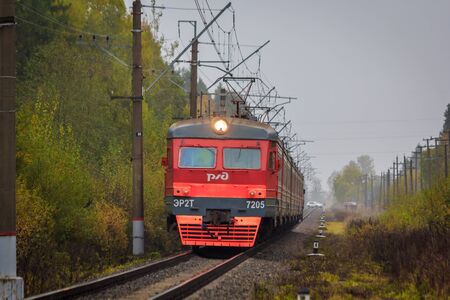Russian train goes by rail outside the city. Public transport. Electric train in the fall. Russia...