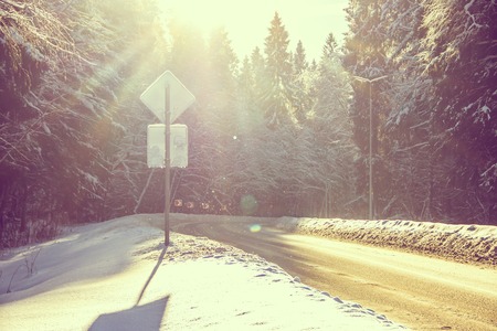 The road in the winter forest. Snow picture. Branches of trees in the snow hang over the road. Beautiful winterの写真素材