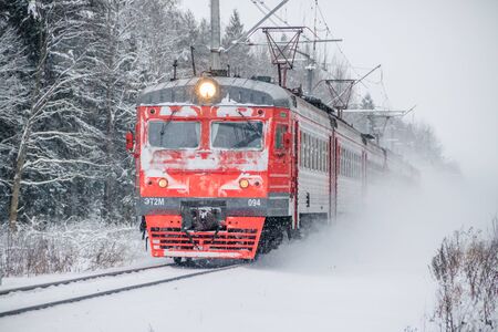 Russian train in the winter. The train rides by rail in the winter in the woods. Winter forest....