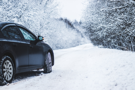 Wheel with spikes on a winter road. Winter road. Snow road. Car on the winter road. Footprints in the snow. Protectedの写真素材