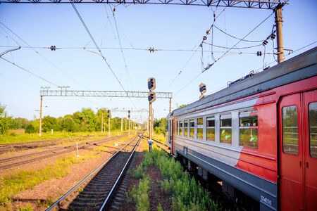 Russian train in the summer. The train rides in the summer at sunset. The train pulls up. Public transport. Russia, Oranienbaum July 31, 2018のeditorial素材