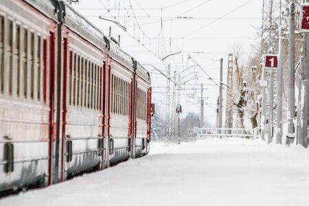 Russian train in the winter. The train on the platform. The train pulls up to the platform. Winter train. Public transport. Russia, Gatchina December 26, 2018のeditorial素材