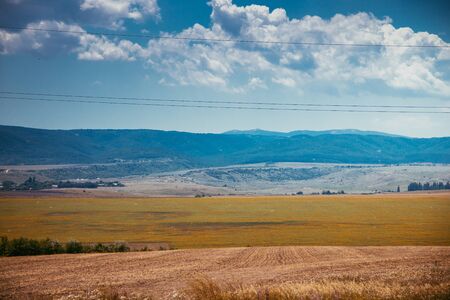 Russian open spaces. Crimea. Field. Summer Russian landscapes. Road views. Grass and sky. Background summer landscape. Crimean fieldsの写真素材