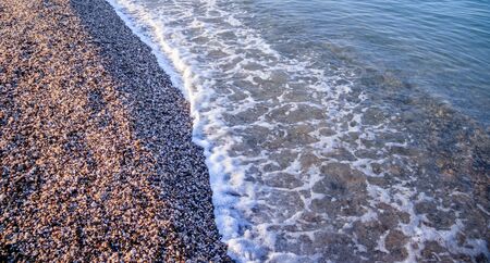 Sea wave in the morning light. Sea wave and beach. Sea wave background. Crimea. Wave and pebble beach. Rest and travel to the sea. Dawnの写真素材