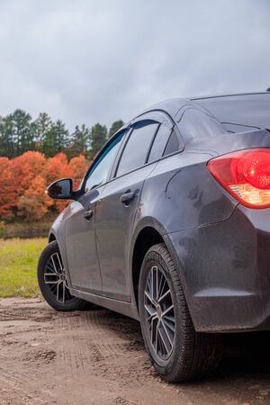 Car on the background of autumn . Black car. Autumn. Russia, Gatchina 30 September 2019のeditorial素材