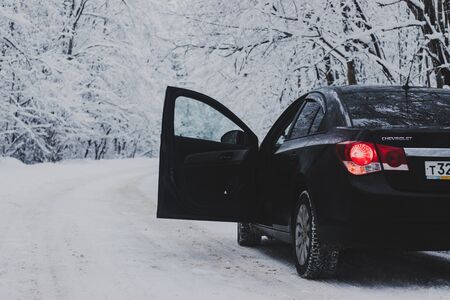 Car in winter in nature outside the city. Snow picture. Snow on the road. Winter road. The white trees. Black car. The car on the road. Journey. 26 December 2018のeditorial素材