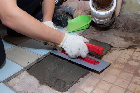 Laying cement on the floor. Fill the floor. Man's work. Master's hand. Liquid cement. A man's hand...