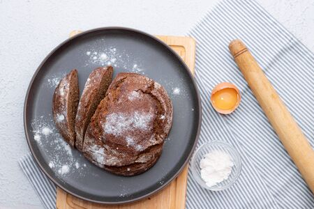 black bread. Homemade cake. Black bread is sprinkled with flour. Freshly baked homemade artisan rye and white flour bread. The view from the top. Space for copying.の写真素材