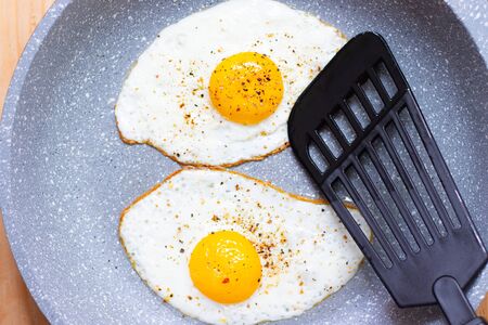 Fried eggs on a plate with green onions . Breakfast. Beautiful serving of the dish. Article about proper nutrition. The seasoning is on the eggの写真素材