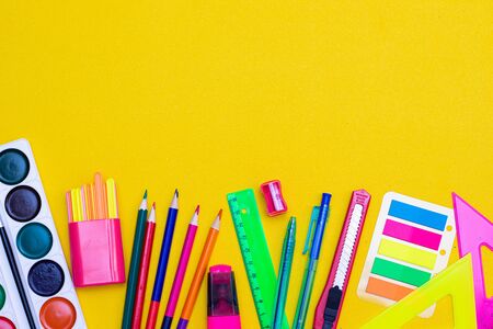 Office supplies on a yellow background. Various school supplies on a bright yellow background. Text frame with office supplies. The layout of the school. Welcome back to school. Concept of advertising office supplies. Flat lay with space for text.の写真素材