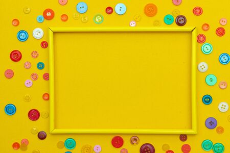 Layout with place for text buttons for clothes. Article about sewing, needlework. Do it yourself. Bright yellow background. Colored buttons.の写真素材