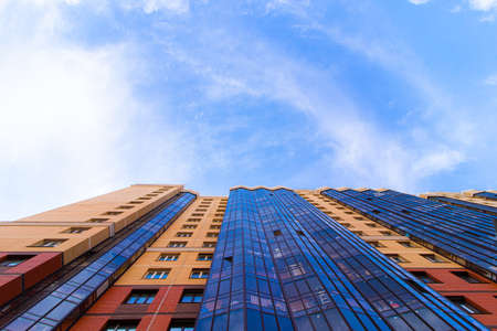 Windows of a high multi-storey residential building. Residential apartment building. Blue sky. Place under the text. Structure. An article about housing. Russia, St. Petersburg April 21, 2020のeditorial素材
