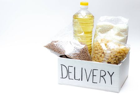 Various canned food, pasta and cereals in a cardboard box.の写真素材