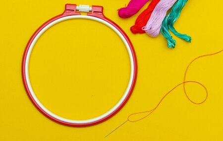 Layout with place for text embroidery. Hobbies and leisure. Do it yourself. Embroidery hoop. Bright threads. Red hoop.の写真素材