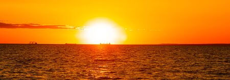 Sunset at sea. Warm sunny sunset over the sea. Sea waves. The sun sets over the horizon. The Gulf of...