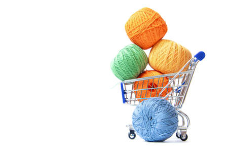 Trolley with yarn for knitting. Yarn for crocheting. Design of the embroidery section. Needlework. Hobbies and recreation. Colored threads on a white background. Isolated objects. Copy spaceの写真素材