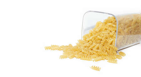 Fusilli macaroni placer. Macaroni spills out of the jar. Article about pasta. Isolated background. Copy space Macaroni. Macaroni bannerの写真素材