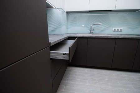 Modern black and white kitchen. The kitchen is in two colors with built-in handles. Opening doors from pressing. Interior. Russia, St. Petersburg April 21, 2020のeditorial素材