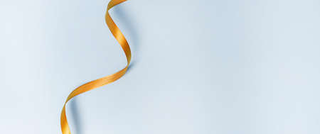 Gold ribbon on a blue background. holiday layout. Decorative ornament. Copy space. The preparation of the article. Blue backgroundの写真素材