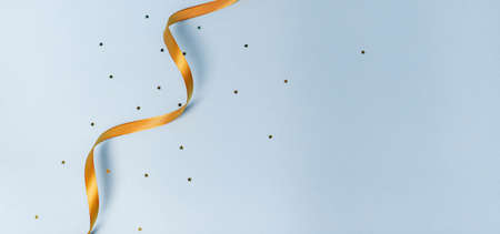 Gold ribbon on a blue background. holiday layout. Decorative ornament. Copy space. The preparation of the article. Blue backgroundの写真素材