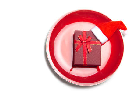 Red gift on a plate. Serving a festive table. New Year and Christmas. Gift wrapping. copy spaceの写真素材