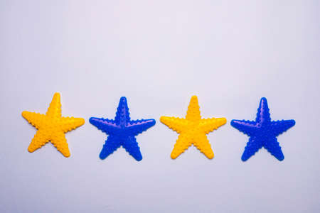 Toys on the bathroom wall. Toys in the bathroom. Toys with suction cups. Blue background. Copy space. The article is about games in the bath. Children's leisure. Washing children. Colored Starfishの写真素材