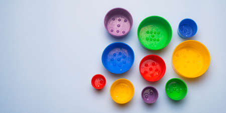 Children's game tower color. Children's pyramid. The game is collect by size. Multi colored pyramid. Water games. The development of the child. Copy space. Blue backgroundの写真素材