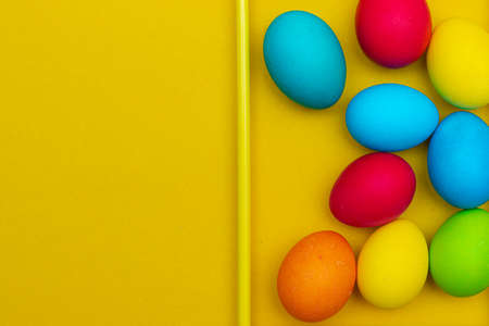 Painted eggs on a yellow background. Chicken eggs on a yellow background in a frame. Space for the text. Chicken eggs are colored. Easter. Orthodox holiday. An article about Easter. Article about eggs benefits and harms. Copy space. Yellow background. Food products. The ingredient.の写真素材