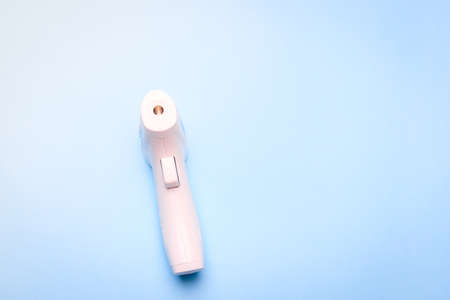 infrared thermometer on a blue background. non-contact temperature measurement. health. human health. check the temperature. copy spaceの写真素材
