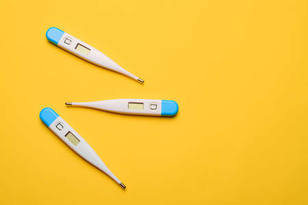 Electronic thermometers. Electronic thermometer on a yellow background. Temperature measurement....