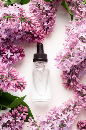 Hyaluronic acid bottle and lilac. Beauty container.の写真素材