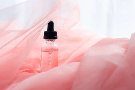 Hyaluronic acid bottle on coral fabric.の写真素材