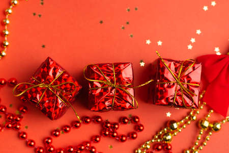Red Christmas gifts and Christmas trees on a red background. An article about the New year and Christmas. The choice of gifts. A red gift. New Year's backgroundの写真素材
