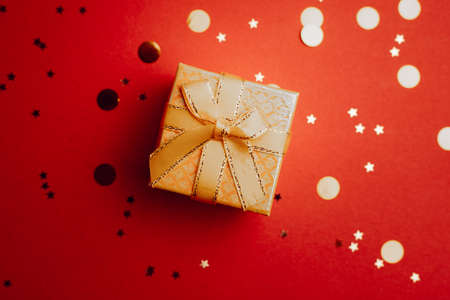 Yellow New Year gift. New Year and Christmas. Copy space. An article about choosing a gift. Red backgroundの写真素材