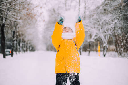 The boy throws snow in winter lifestyle . Winter walks. An article about childrens winter leisure.の写真素材