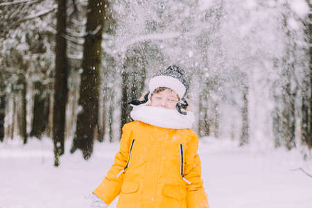 The boy throws snow in winter lifestyle . Winter walks. An article about childrens winter leisure.の写真素材