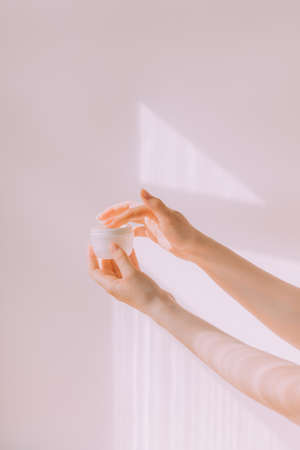 Women's hands hold a cosmetic copy space cream. An article about care cosmetics. hand cream. face cream.の写真素材